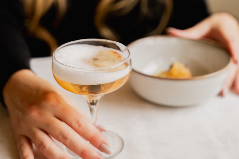 Cocktail élégant en coupe avec mousse servi avec bol de dessert dans un bar chic