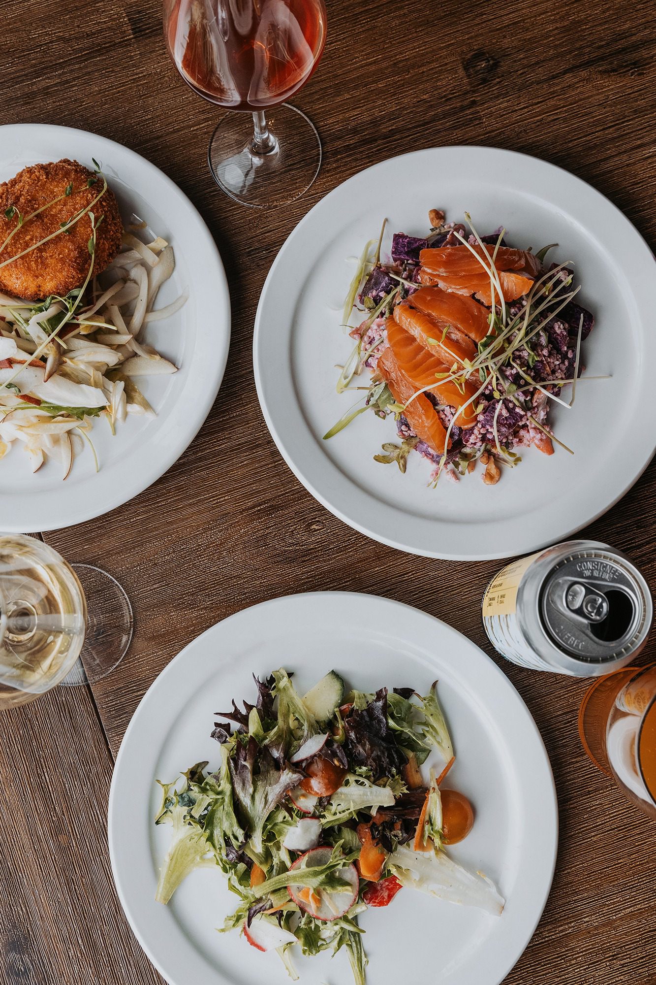 Assiettes de plats gastronomiques colorés vue du dessus sur table en bois avec vin rosé