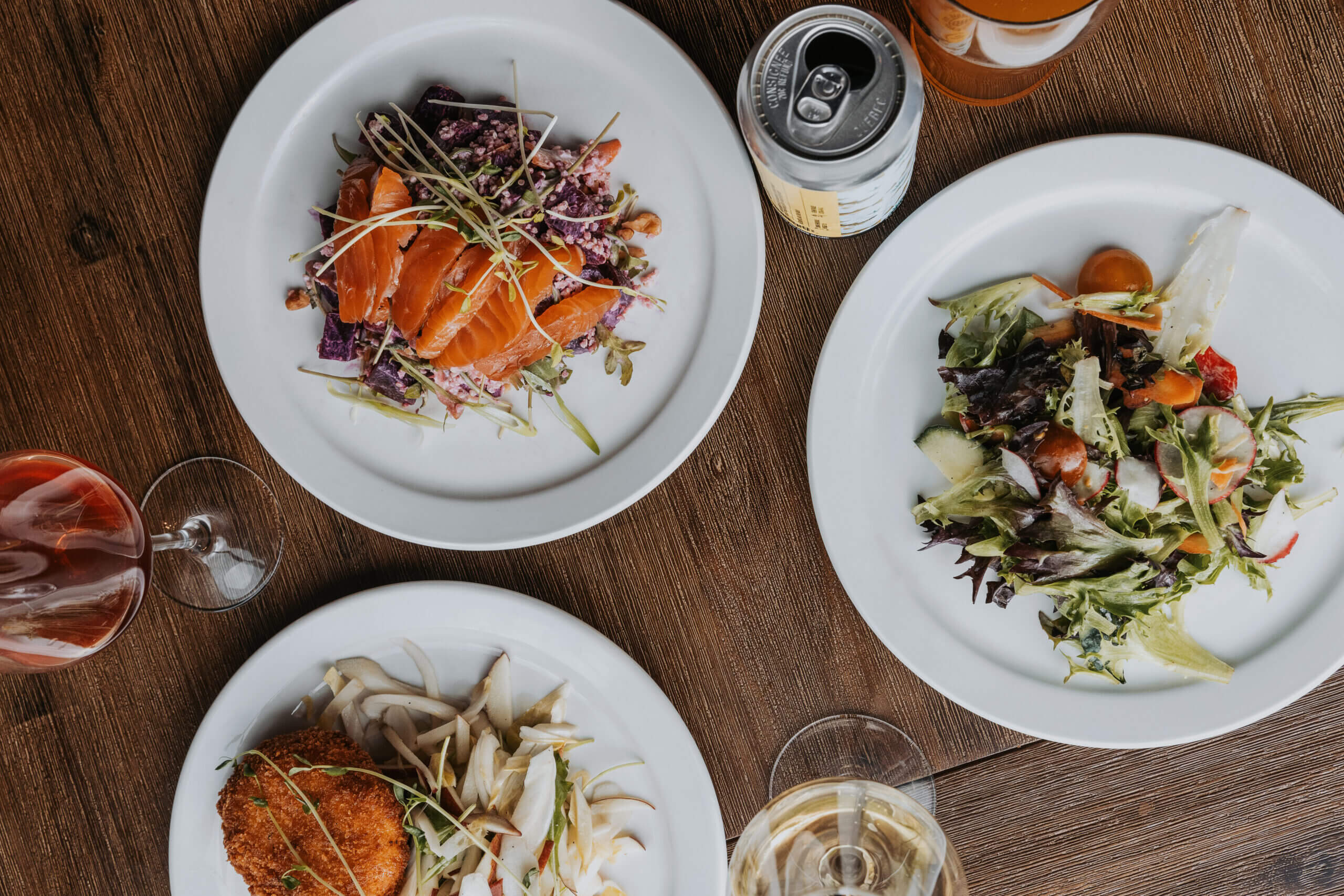 Assiettes de plats gastronomiques vue du dessus sur table en bois avec verres de vin