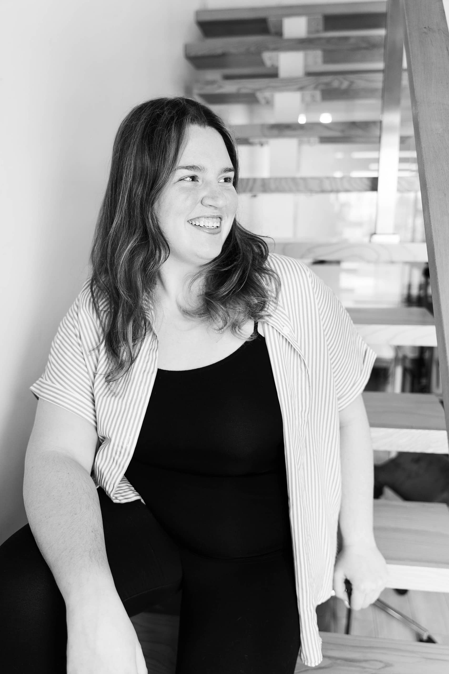 Portrait professionnel noir et blanc d'Emmanuelle membre de l'équipe Solutions M souriante
